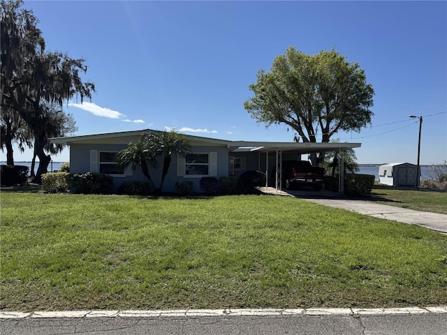 ranch-style house featuring a front yard, driveway, an attached carport, and stucco siding