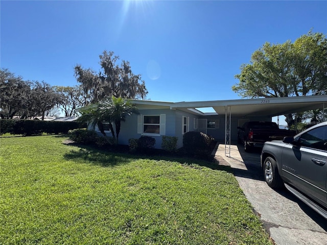 view of side of home with driveway, a carport, and a yard