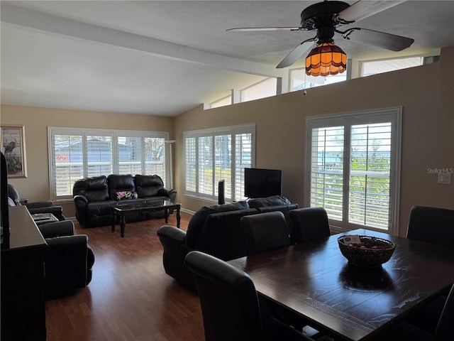 dining space with vaulted ceiling with beams, wood finished floors, a ceiling fan, and baseboards