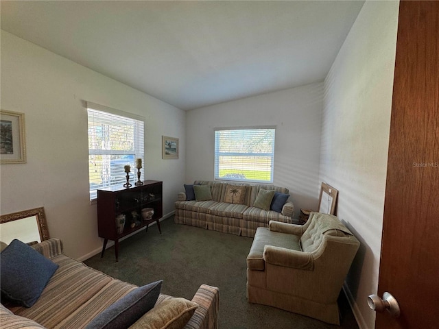 carpeted living area with lofted ceiling and baseboards