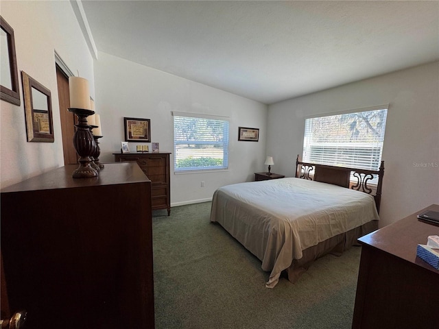 bedroom featuring baseboards, dark carpet, and vaulted ceiling