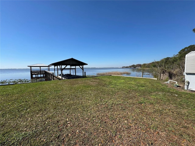 dock area with a water view and a yard