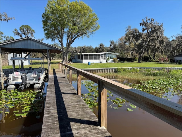 view of dock with a lawn and a water view