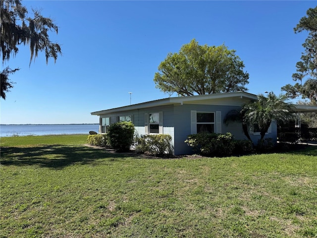 view of home's exterior featuring a water view and a lawn