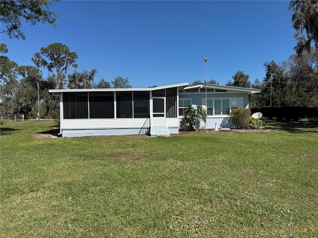 back of house featuring a yard and a sunroom