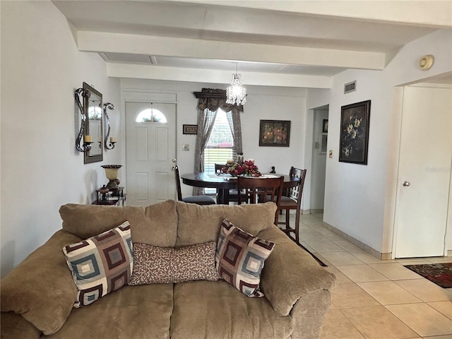 living room featuring beam ceiling, light tile patterned flooring, visible vents, and a notable chandelier