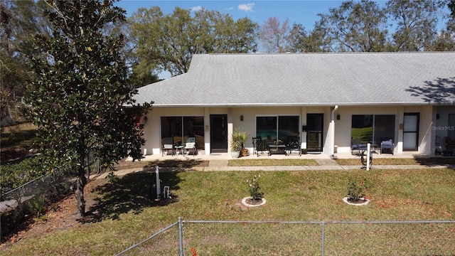 rear view of house featuring stucco siding, a patio, a lawn, and fence