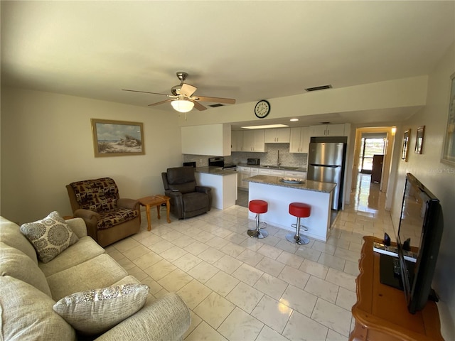 living room with visible vents and a ceiling fan