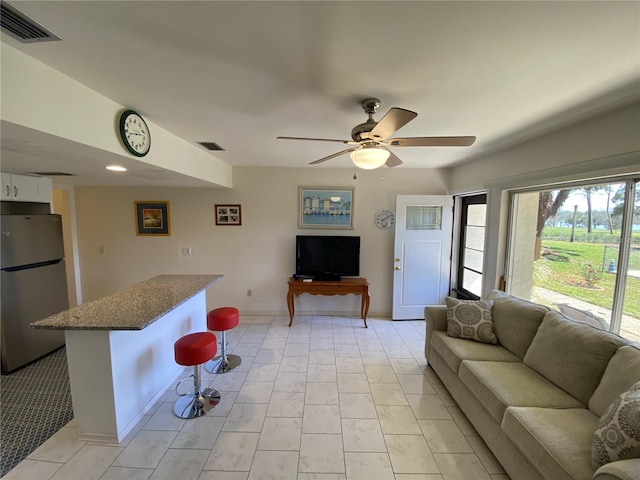 living area featuring visible vents and a ceiling fan