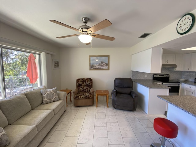 living area featuring ceiling fan and visible vents