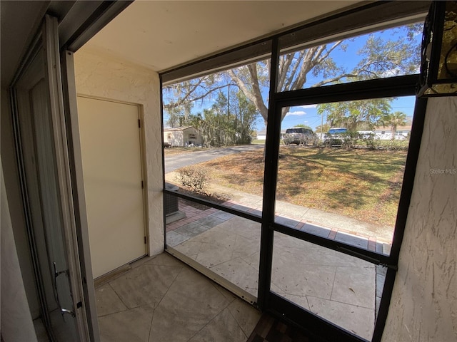 doorway featuring a textured wall and tile patterned flooring