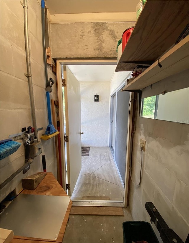 hallway featuring concrete block wall