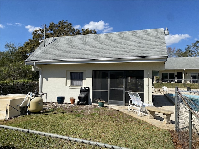 rear view of property with a yard, roof with shingles, and stucco siding