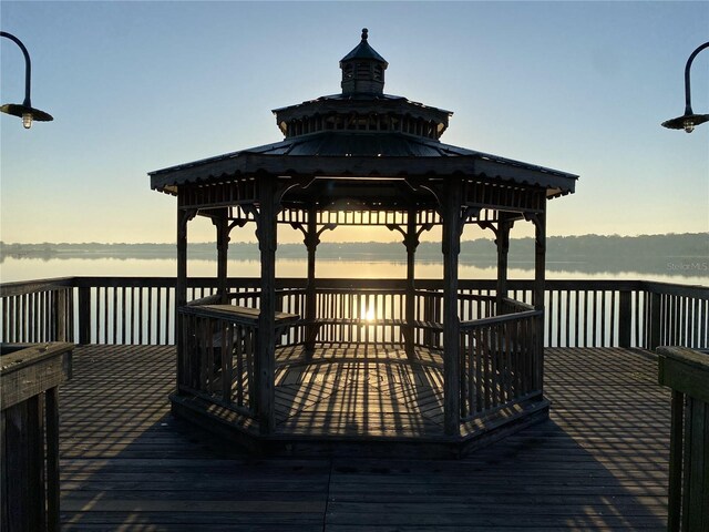 view of dock with a deck with water view and a gazebo