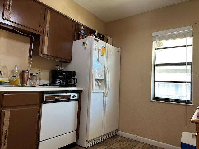 kitchen with white appliances, light countertops, and baseboards