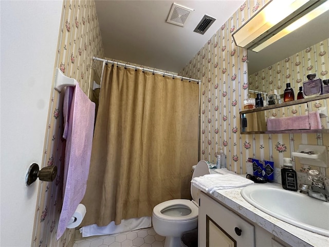 bathroom featuring wallpapered walls, toilet, vanity, and visible vents