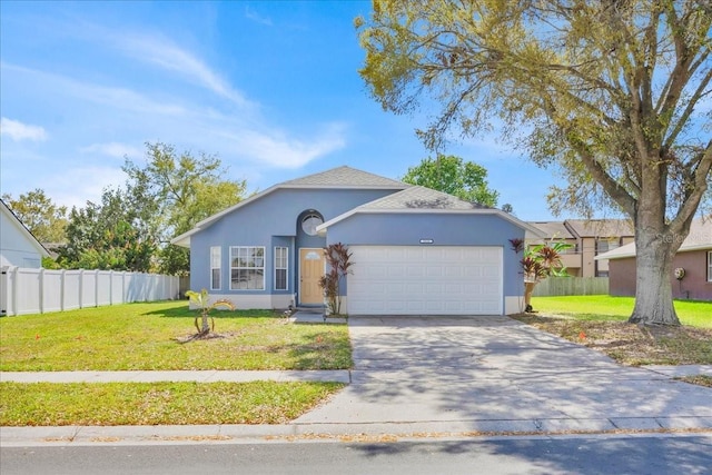 ranch-style home with concrete driveway, an attached garage, fence, a front lawn, and stucco siding