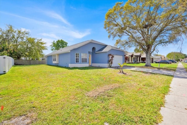 ranch-style house with an attached garage, fence, driveway, stucco siding, and a front yard