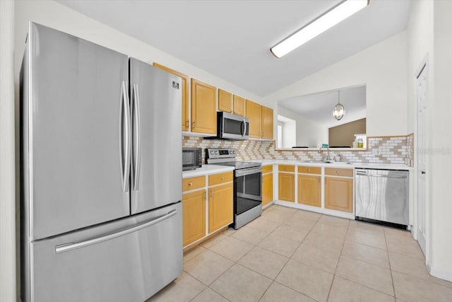 kitchen with tasteful backsplash, lofted ceiling, appliances with stainless steel finishes, light countertops, and a sink