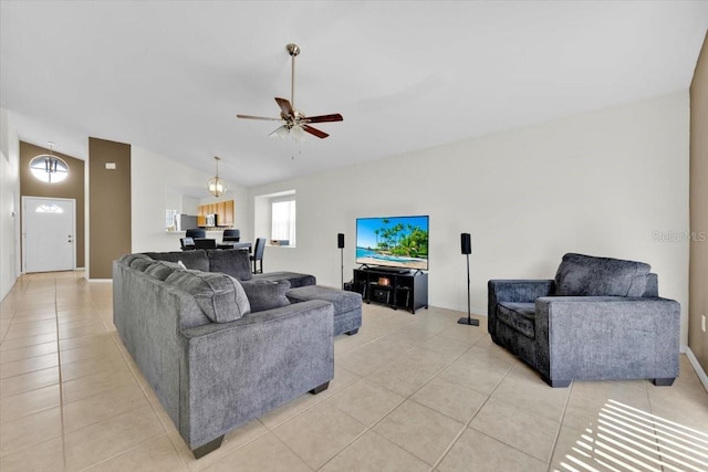 living area featuring a ceiling fan, lofted ceiling, and light tile patterned flooring