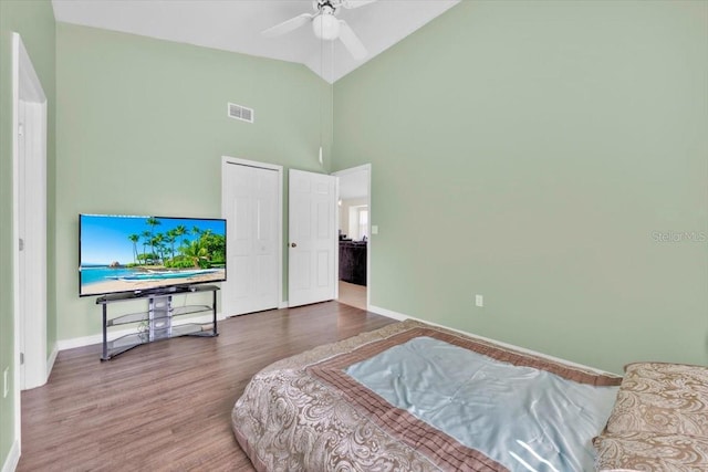 bedroom with visible vents, ceiling fan, wood finished floors, high vaulted ceiling, and baseboards