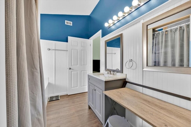 bathroom featuring a shower with curtain, visible vents, vanity, and wood finished floors