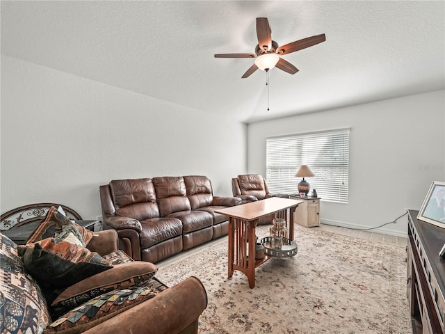 living room with a textured ceiling, lofted ceiling, and ceiling fan