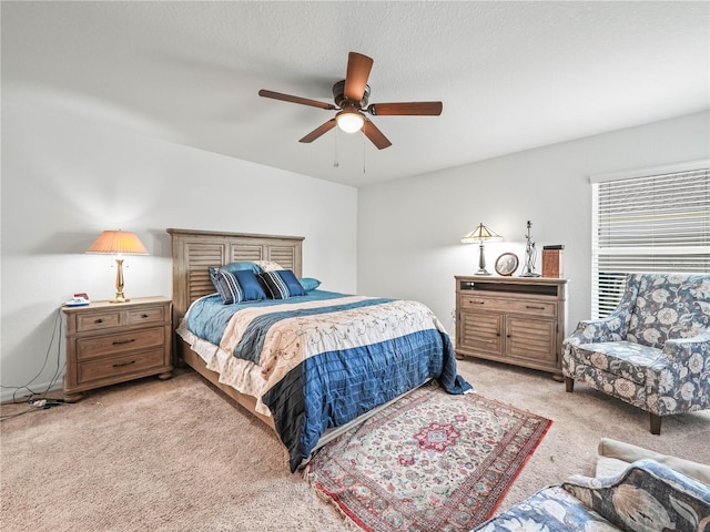 bedroom featuring light colored carpet, a textured ceiling, and ceiling fan