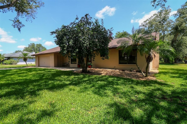 3567 Red Oak Ct, Lake Wales, FL 33898 - view of front facade with an attached garage, a front lawn, and stucco siding