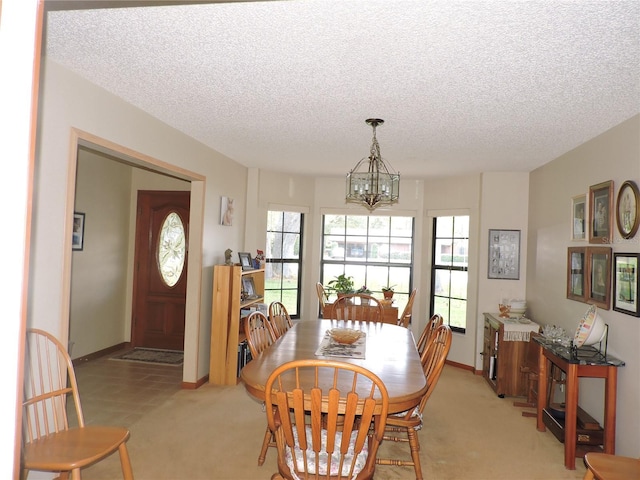 3567 Red Oak Ct, Lake Wales, FL 33898 - dining room featuring a chandelier, light carpet, a textured ceiling, and baseboards