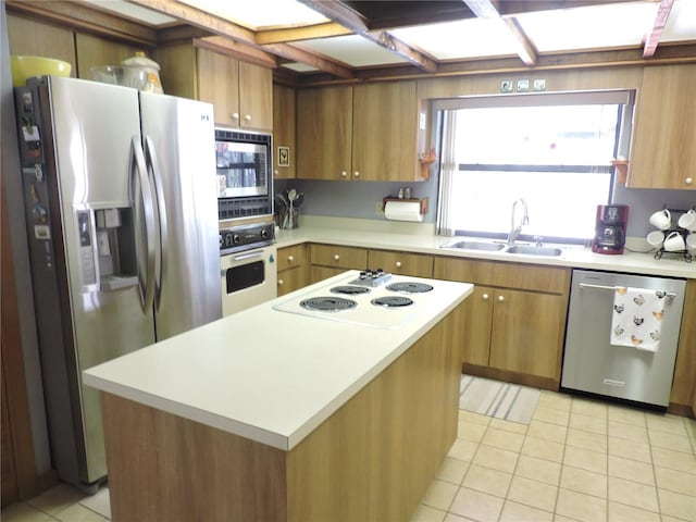 3567 Red Oak Ct, Lake Wales, FL 33898 - kitchen featuring appliances with stainless steel finishes, a sink, light countertops, light tile patterned floors, and brown cabinetry