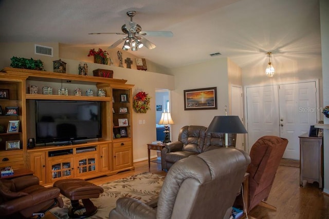 living room featuring visible vents, ceiling fan, vaulted ceiling, and light wood-style flooring