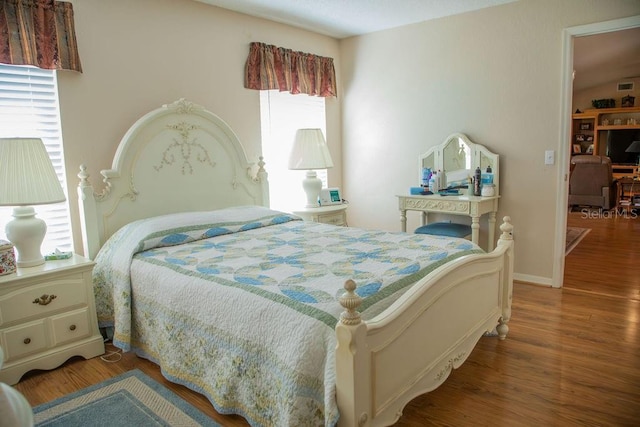 bedroom with baseboards and wood finished floors