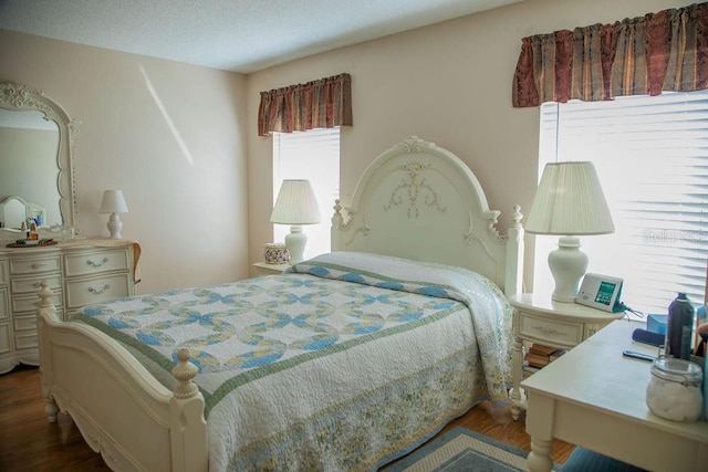 bedroom featuring a textured ceiling and wood finished floors