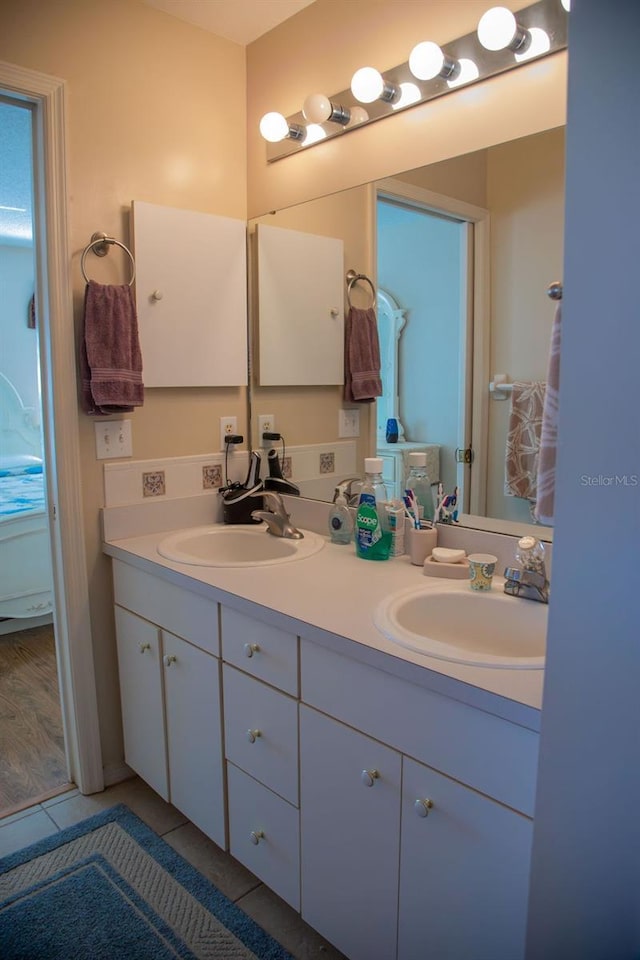 full bathroom with a sink, double vanity, and tile patterned flooring