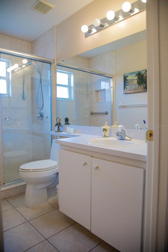 full bathroom featuring vanity, a stall shower, tile patterned floors, toilet, and visible vents