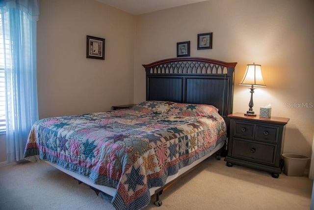bedroom with multiple windows and light colored carpet