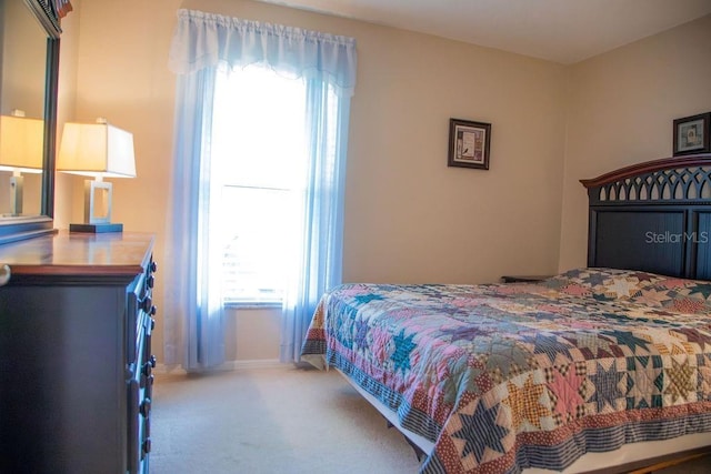bedroom with baseboards and carpet