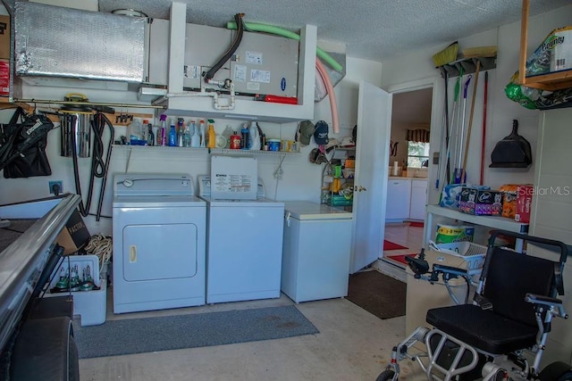 clothes washing area with washer and dryer, laundry area, and a textured ceiling
