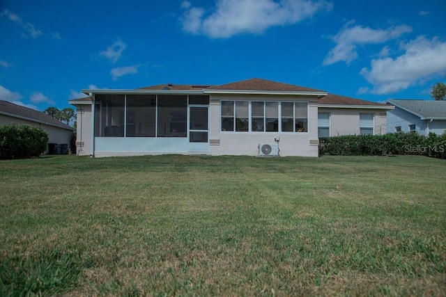back of house with a sunroom and a lawn