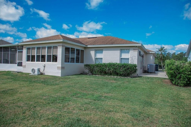 rear view of property featuring ac unit, cooling unit, a sunroom, stucco siding, and a lawn