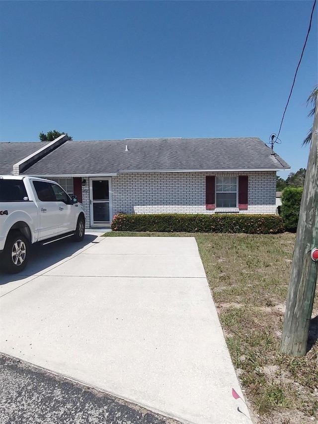 1402 Thousand Roses Dr W Unit 1402, Lake Wales, FL 33853 - view of front facade with brick siding and a front lawn