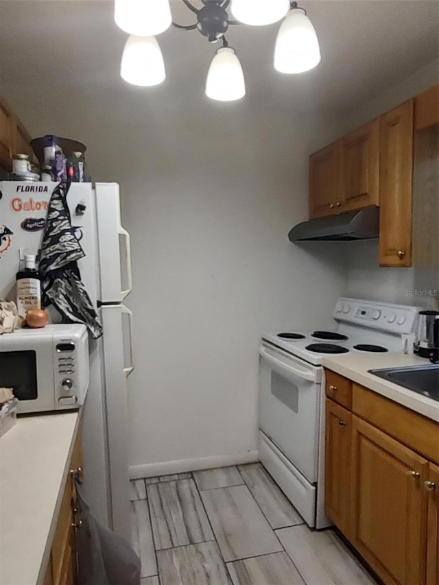 1402 Thousand Roses Dr W Unit 1402, Lake Wales, FL 33853 - kitchen with white appliances, exhaust hood, brown cabinets, light countertops, and a sink