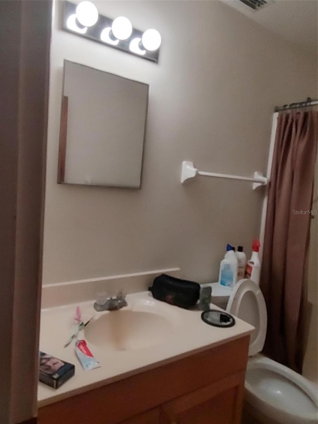1402 Thousand Roses Dr W Unit 1402, Lake Wales, FL 33853 - bathroom with vanity, toilet, and a shower with shower curtain