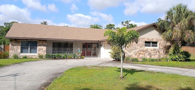 ranch-style house with a porch, stone siding, a front lawn, and concrete driveway