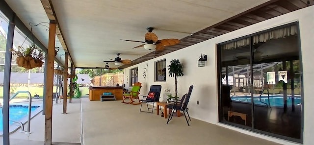 view of patio / terrace with a ceiling fan, a hot tub, an outdoor pool, and fence