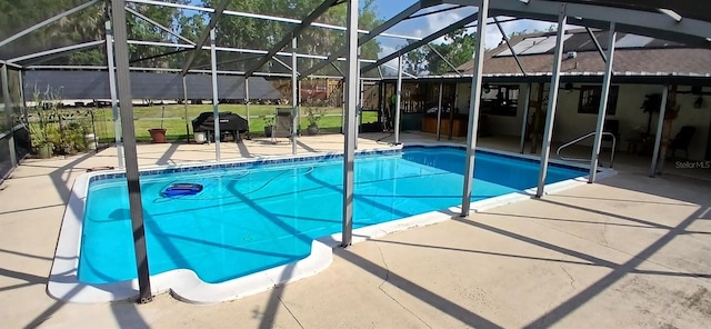 pool featuring glass enclosure, a patio, and a grill