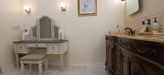 bathroom with wood finished floors, vanity, and baseboards