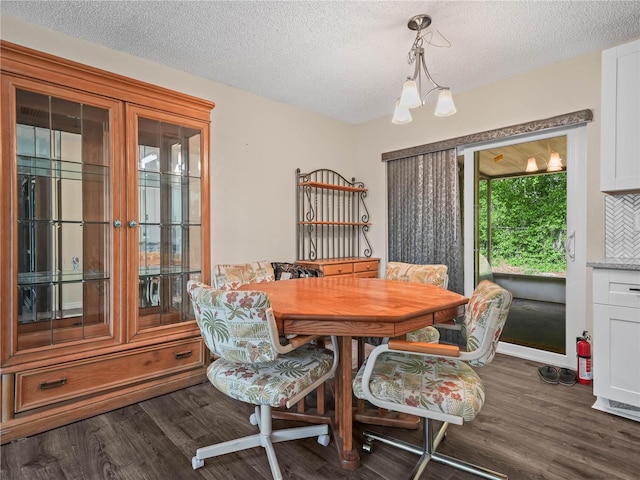 dining area featuring dark wood-style flooring and a textured ceiling