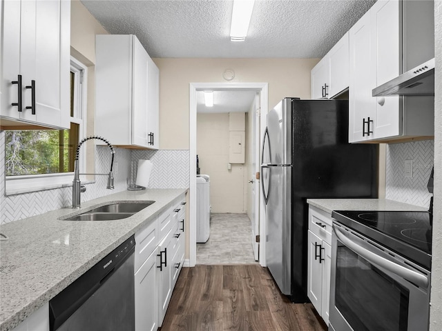 kitchen featuring appliances with stainless steel finishes, dark wood finished floors, a sink, white cabinets, and under cabinet range hood